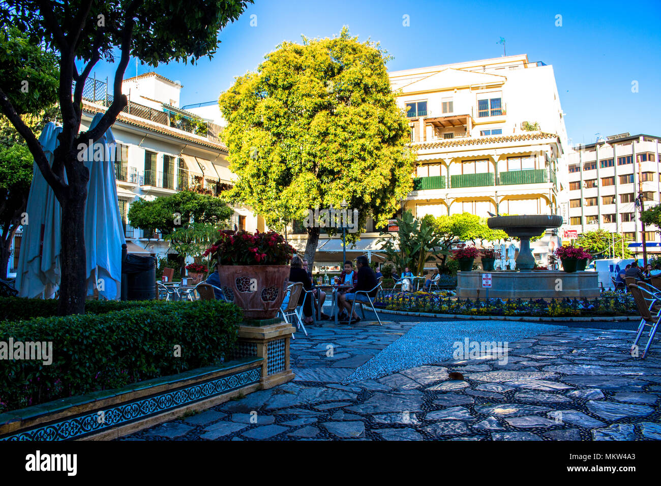 Platz. Ein kleiner Platz mit Restaurants und einem Brunnen in Estepona. Provinz Malaga, Andalusien, Spanien. Bild genommen - 4. Mai 2018. Stockfoto