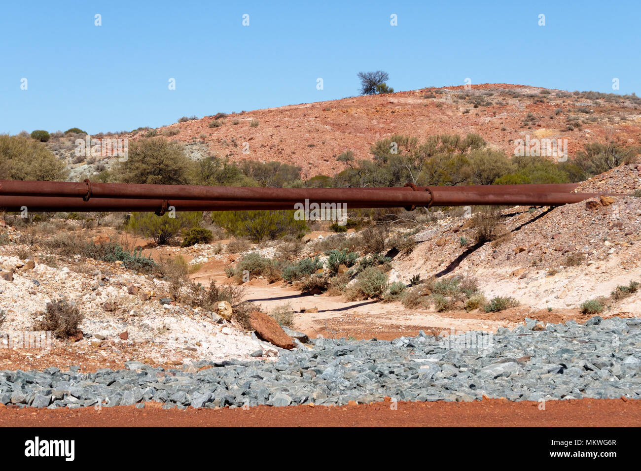 Rostiges Wasser Leitungen Überqueren einer Dry Creek Bed, Eastern Goldfields, Western Australia Stockfoto
