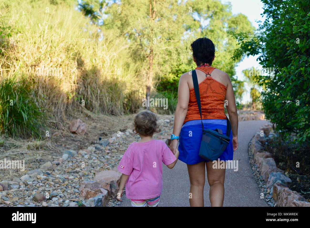 Eine Mutter und Kinder Spaziergang entlang einem Pfad in einem botanischen Garten wie Einstellung Stockfoto