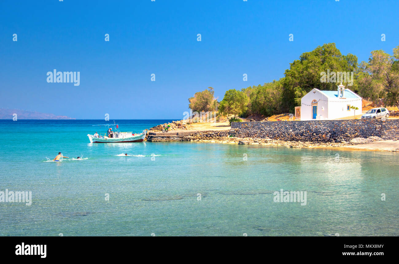 Gruppe von jungen Spaß an den schönen Strand in Istron, Kreta, Griechenland typisch griechischen Insel Blick auf den Strand, blaues Meer und Holz- Fischerboot. Stockfoto