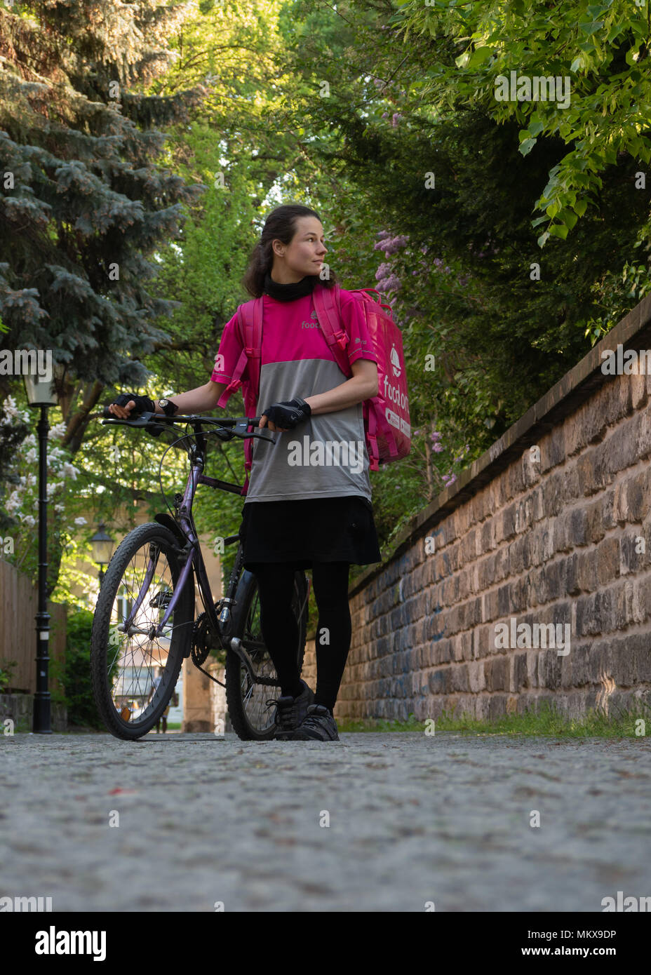 Dresden, Deutschland: Essen Lieferservice. Eine foodora Mitarbeiter gehen ihr Fahrrad beim Warten auf neue Aufträge zu kommen. Stockfoto