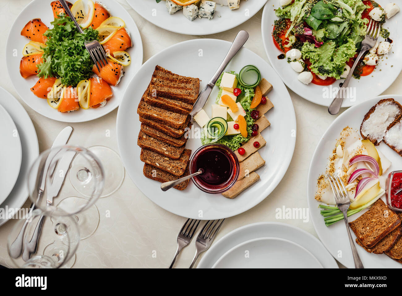 Serviert Gerichte auf den Tisch, für Ihren Urlaub. Geschirr und Essen auf weiße Tischdecken im Restaurant. Design ein festliches Bankett. Luxuriöses Essen für Gäste und Besucher. Stockfoto
