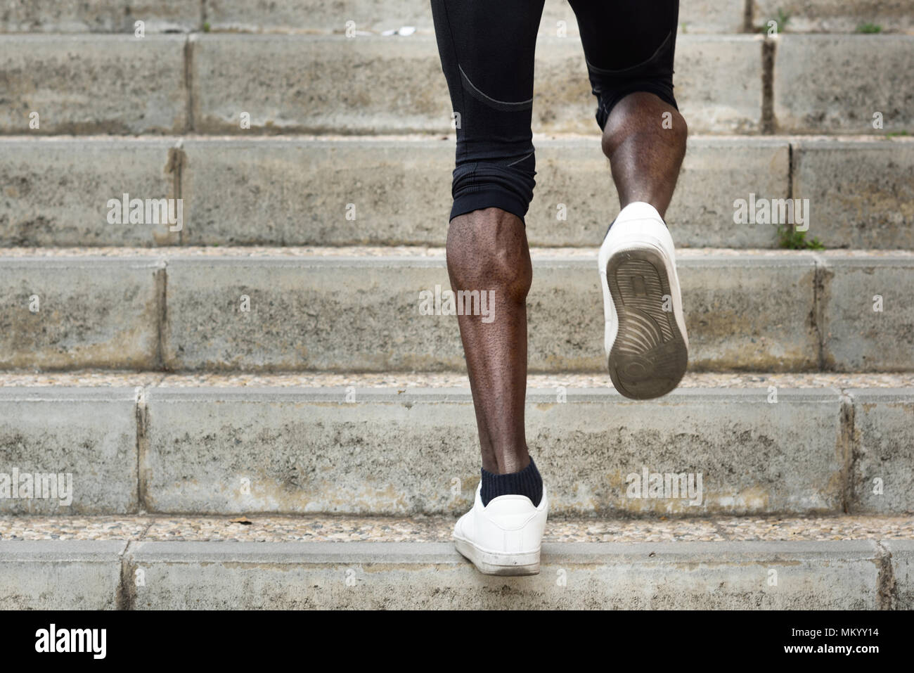 Athletische Beine mit schwarzen Sport Mann mit starken Muskeln auf Treppenstufen. Afrikanische Mann joggen in städtischen Ausbildung Training. Stockfoto