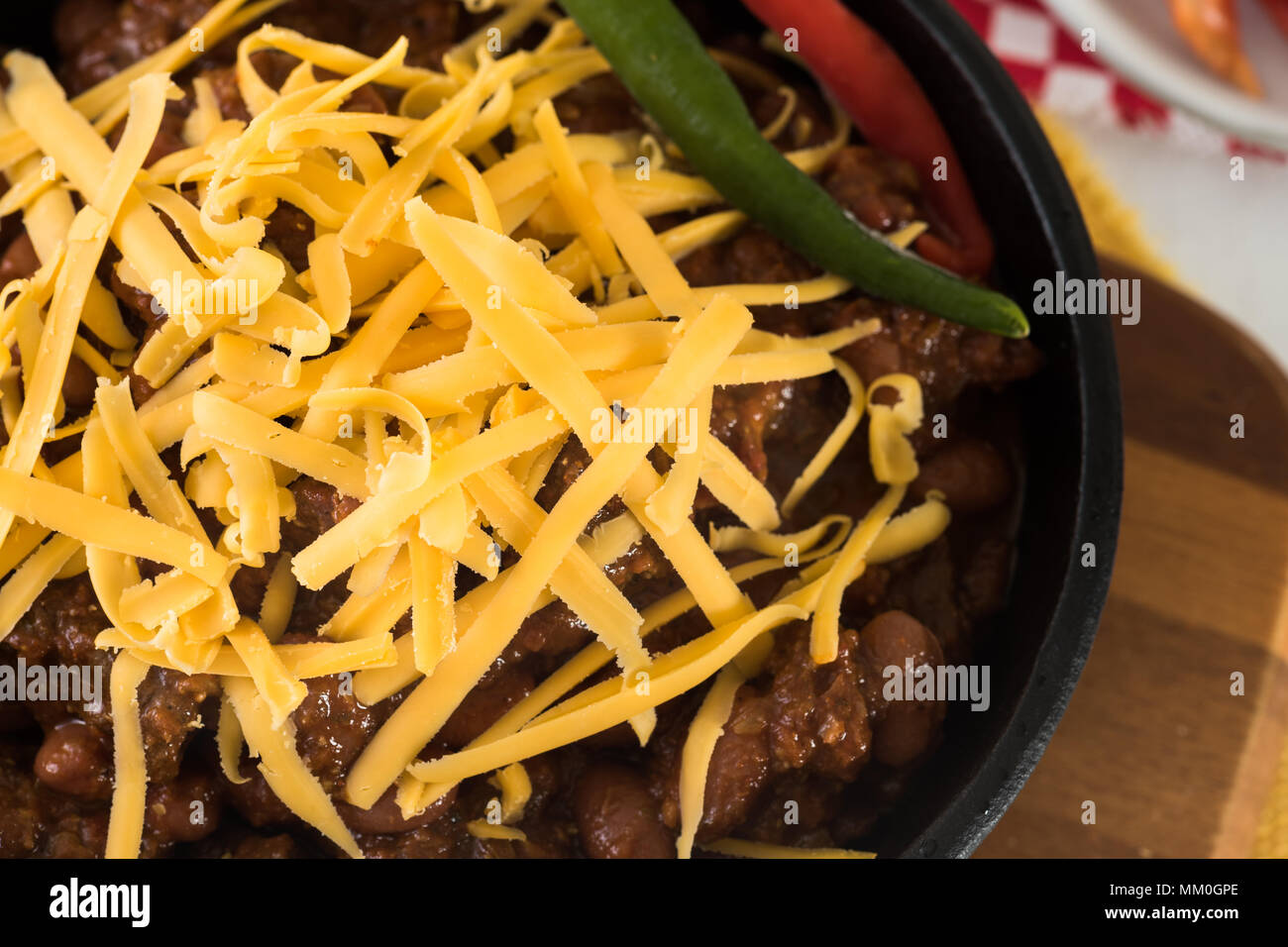 Gusseisen Skillet voll mit würzigen Rindfleisch und Bean Chili mit Cheddar Käse. Stockfoto