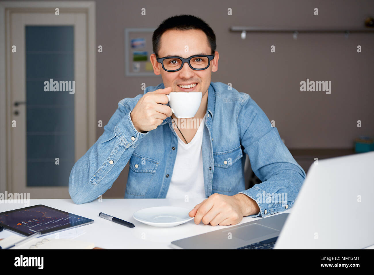 Mann in Gläsern auf dem Laptop von zu Hause aus arbeiten Stockfoto