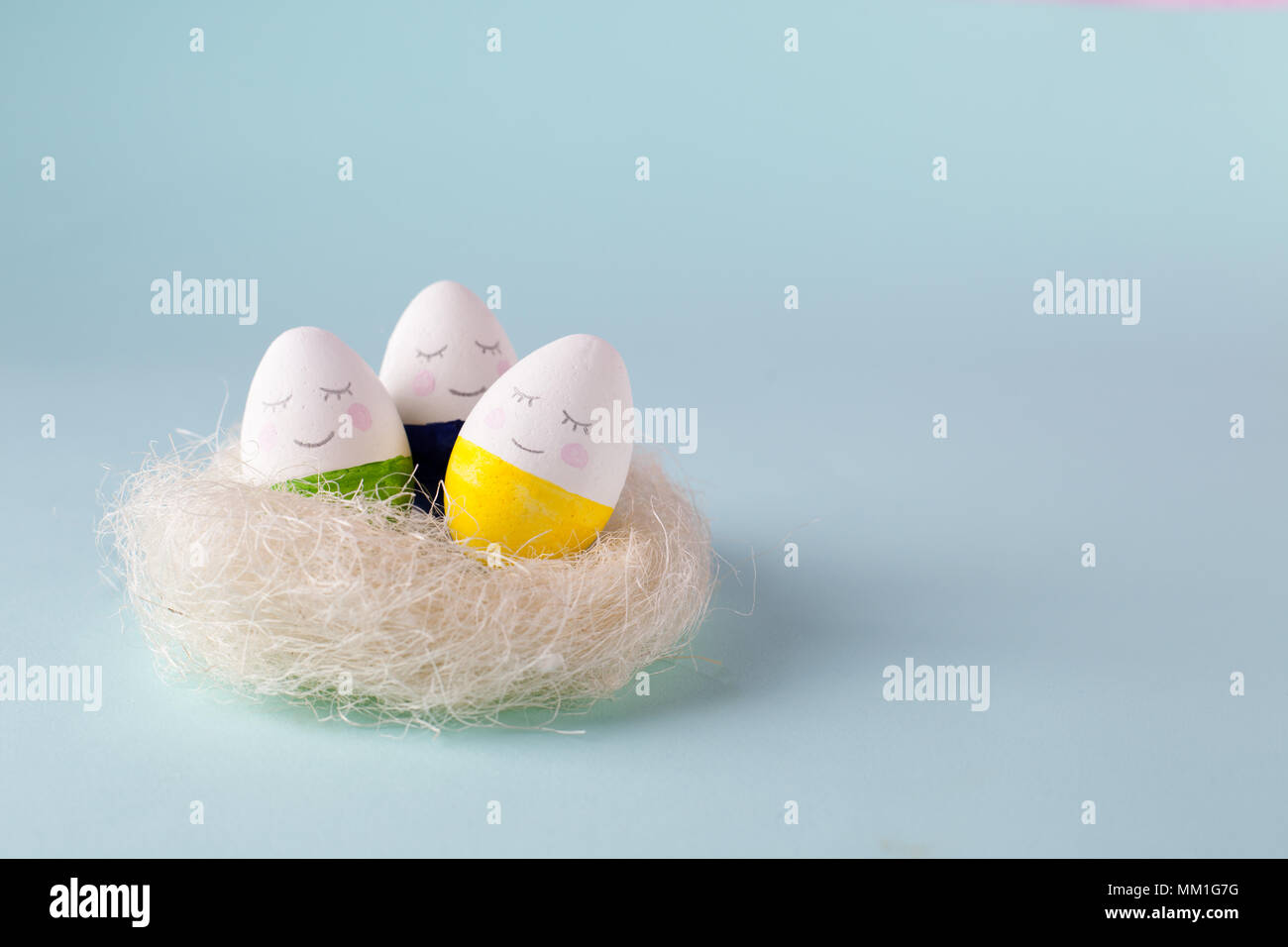 Lustige süße Eier im Nest jon Blau pastell Hintergrund, trendige Entspannung Konzept ziehen Stockfoto