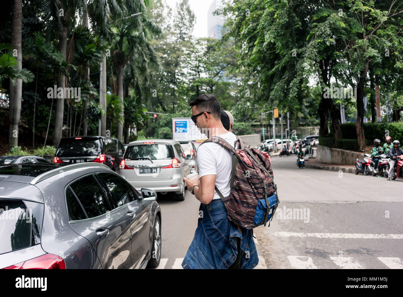 Jungen Touristen zu Fuß auf einen Fußgängerüberweg während einer Stadt für den Sommer-pause Stockfoto