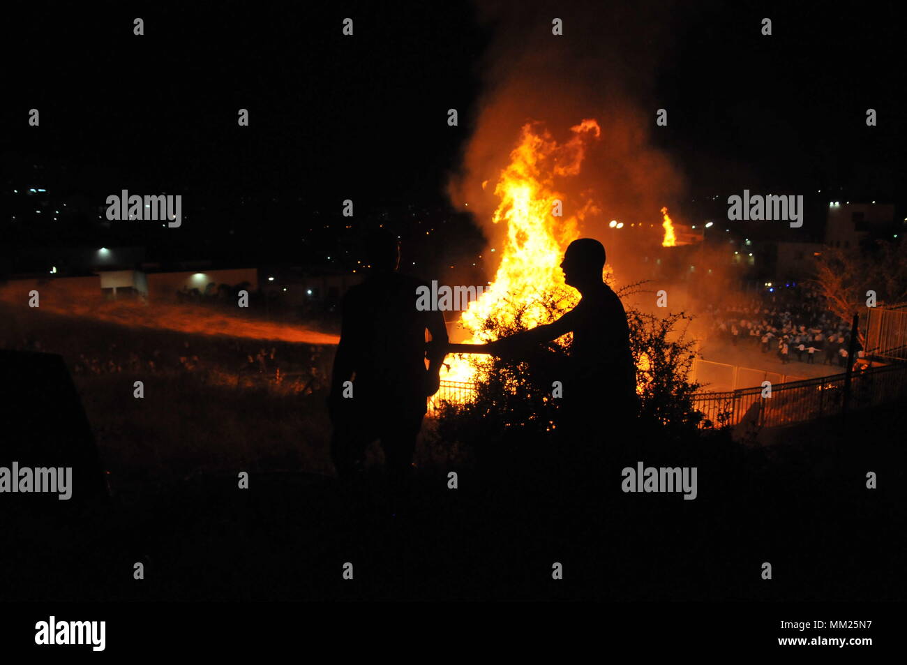 Feuerwehrmann ein großes Lagerfeuer, während die Lag B'Omer feiern (Lag B'Omer ist ein Tag für Lagerfeuer feiern löschen.) Stockfoto
