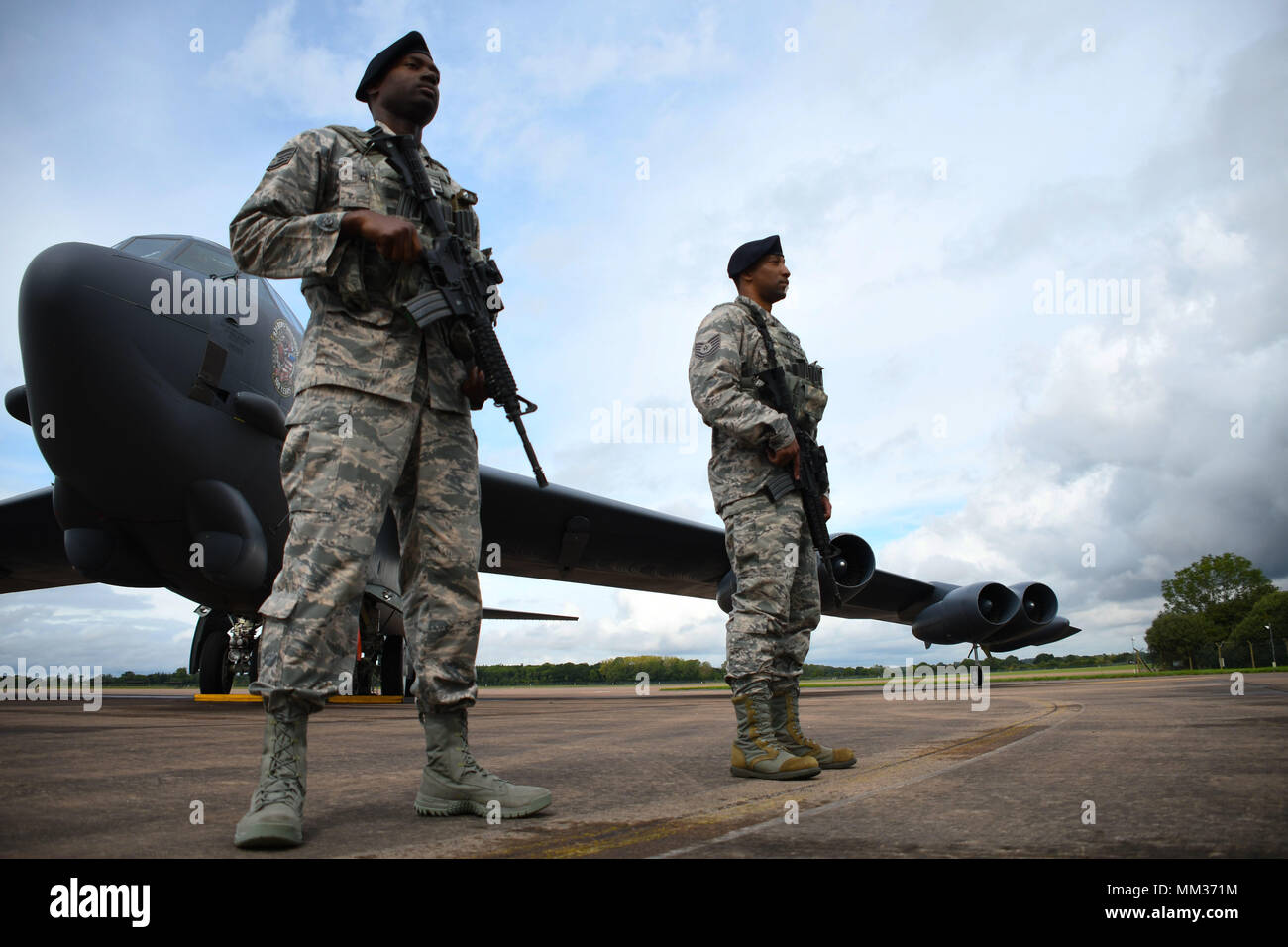 Flieger der 307th Security Forces Squadron guard a B-52 Stratofortress bei Royal Air Force Fairford, Vereinigtes Königreich, Sept. 4, 2017. Der Strahl wird in der Übung reichlich Streik 2017 geflogen, eine Tschechische Republik - live Übung, die Vorauszahlung Luft/Land Integration Training bietet, Fluglotsen, gemeinsame Endgerät angreifen Steuerungen und Close Air Support Flugzeugbesatzungen. Sowohl die B-52 und B-1B Lancer nahmen an der übung US-Engagement für die NATO-Verbündeten und Partner zu zeigen. (U.S. Air Force Foto von Master Sgt. Ted Daigle/freigegeben) Stockfoto