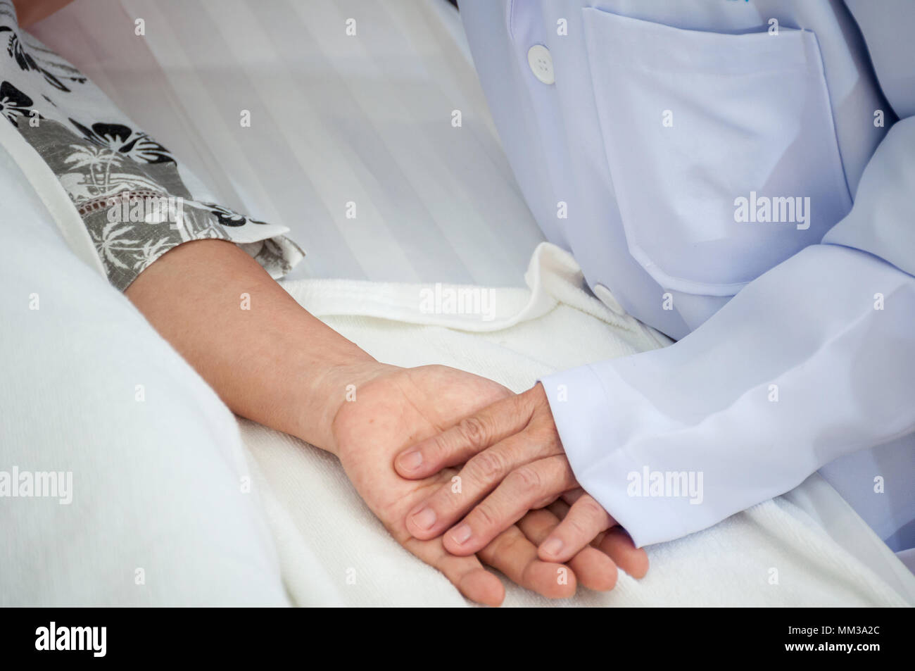 Close-up Ärztliche Betreuung halten Hand Großmutter schlafen bei älteren Patienten mit nach Hause nehmen. Stockfoto
