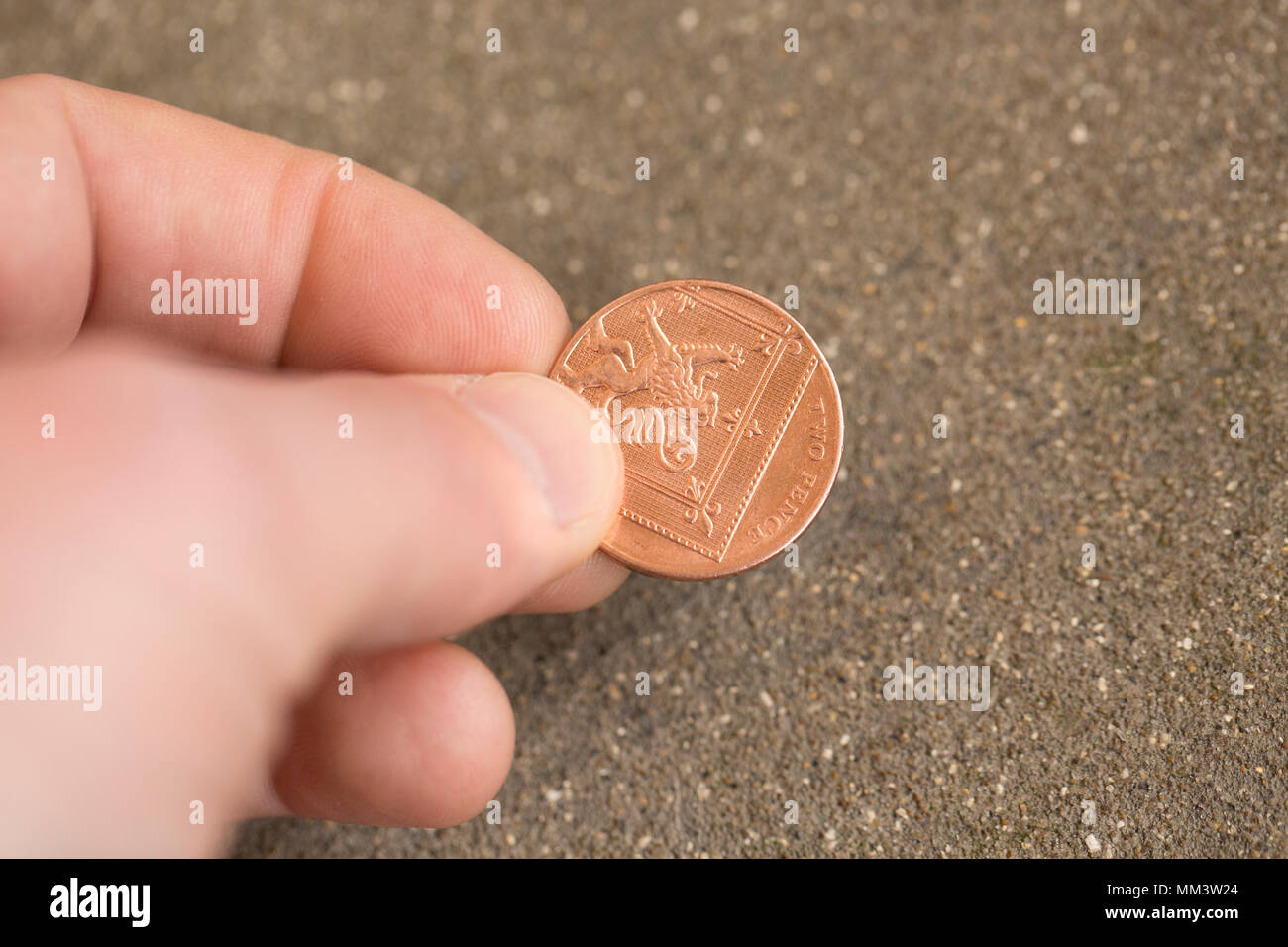 Stellen Bild von der Aufnahme einer zwei Pence Stück aus dem Boden. Großbritannien Stockfoto