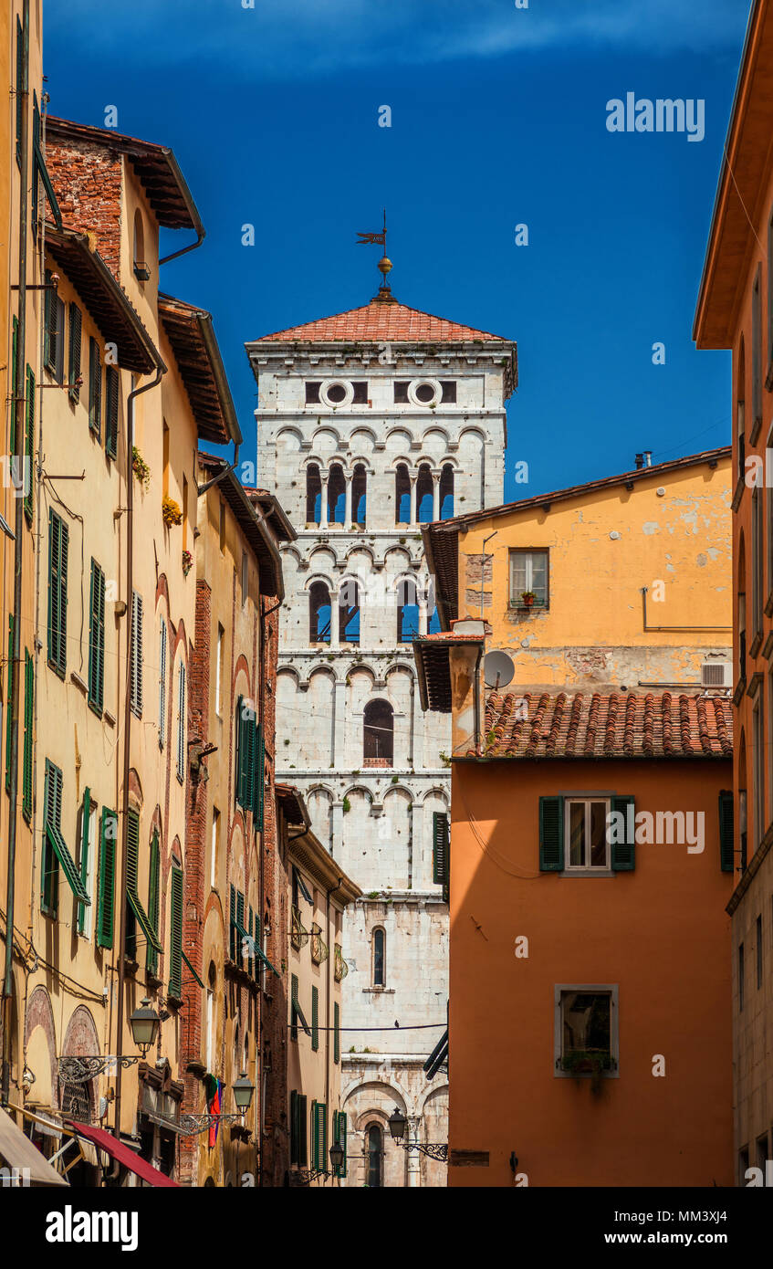 Blick auf Lucca Altstadt mit St. Michael in Foro mittelalterlichen Glockenturm von Stadt engen Straße aus gesehen Stockfoto