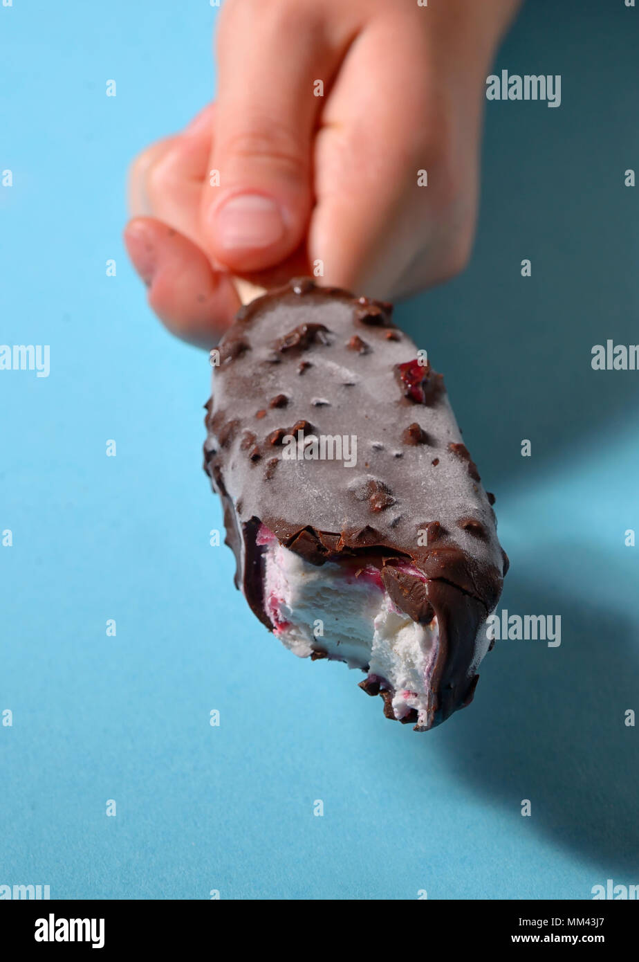 Hand beißen Eis Stockfoto