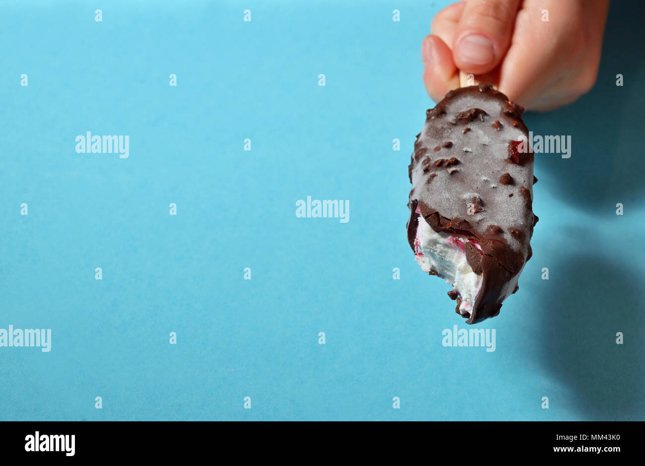 Hand beißen Eis Stockfoto