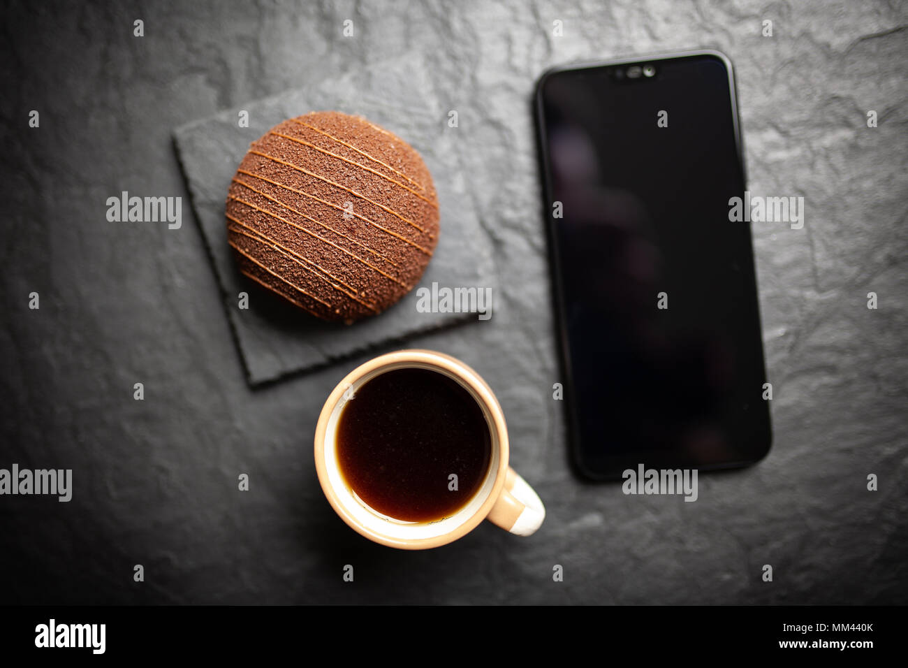 Kaffee, Dessert und ein Smartphone Stockfoto