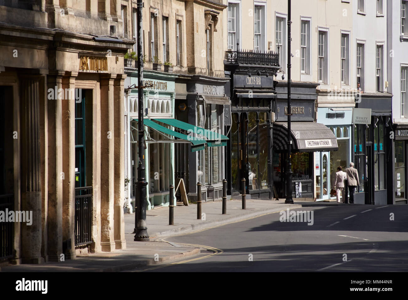 Geschäfte und Bars und Restaurants in Montpellier, Cheltenham. Zwei Fußgänger in der Ferne. Stockfoto