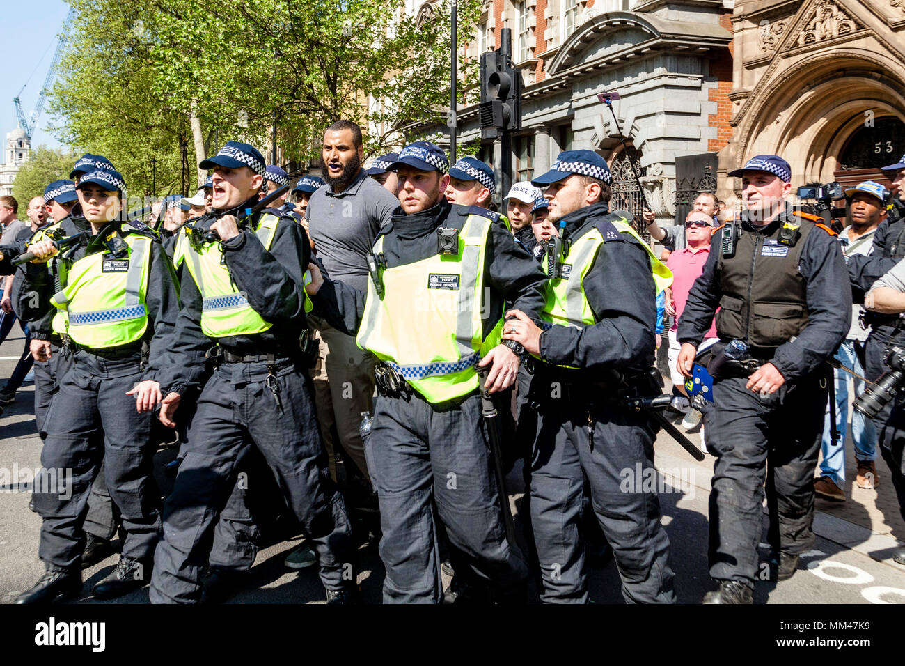 Die Metropolitan Police Officers escort Prominente muslimische Sprecher Muhammed Hijab entfernt von einer Freiheit der Rede Rally, London, UK Stockfoto