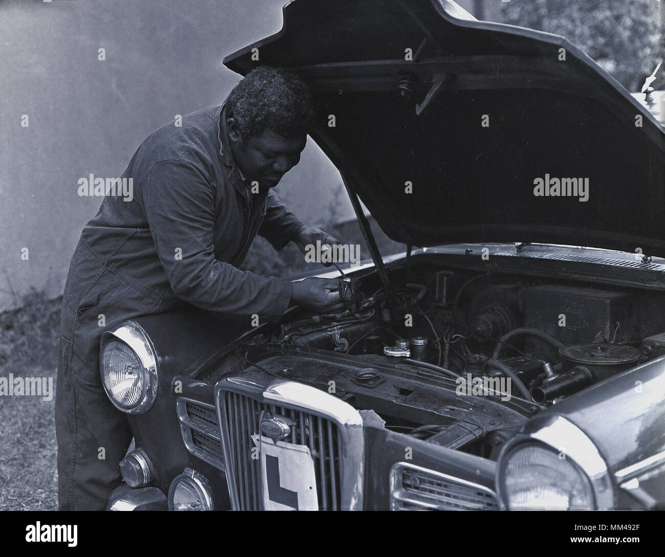 1970 s, erwachsenen männlichen Mechaniker Prüfen des Ölstands im Motor eines britischen Wolsely Motor Car, England, Grossbritannien. Stockfoto