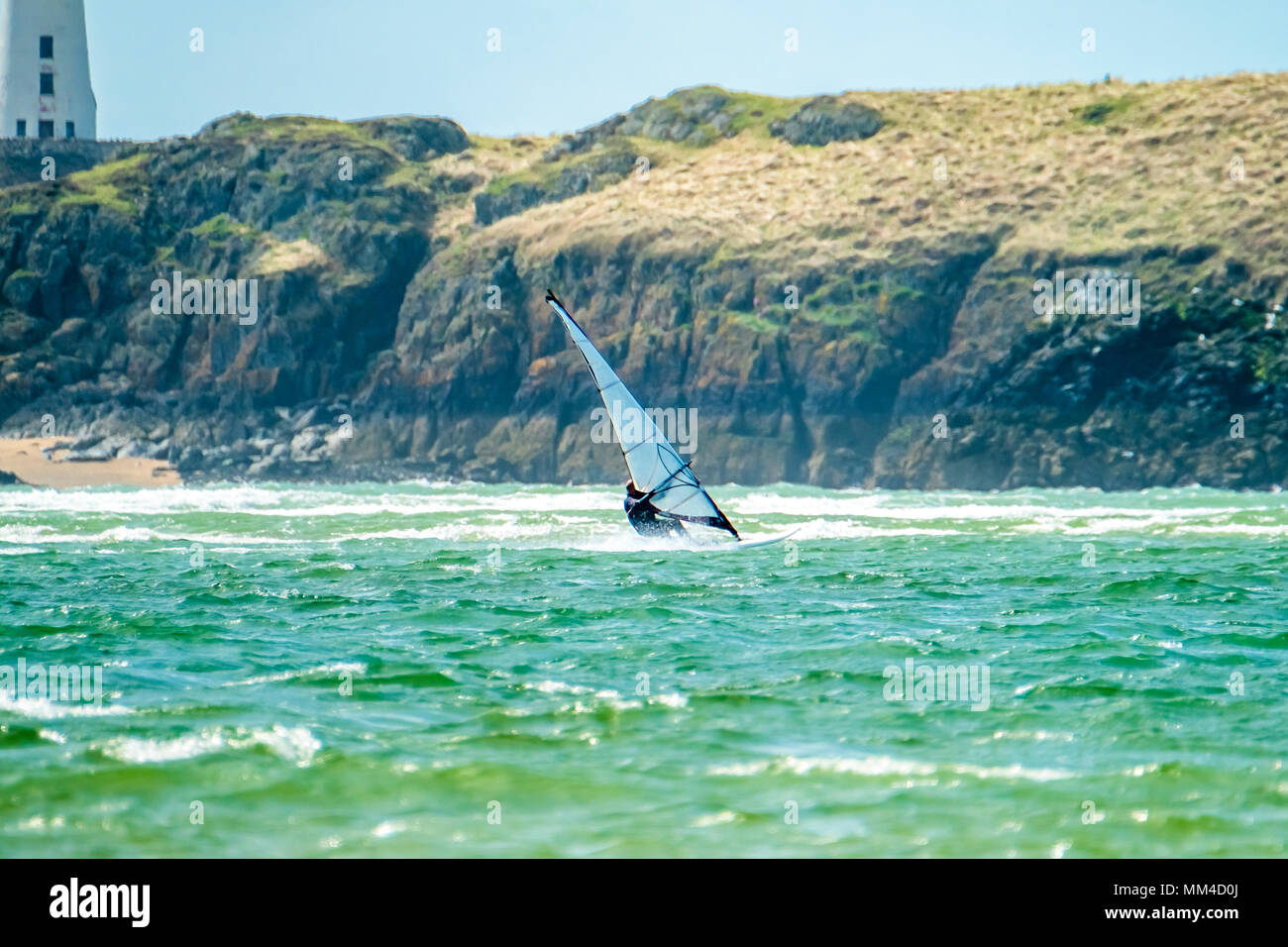 Wind surfer genießt den Strand bei filey Warren mit der Insel Llanddwyn im Hintergrund, auf der Insel Anglesey, Nordwales, Vereinigtes Königreich Stockfoto