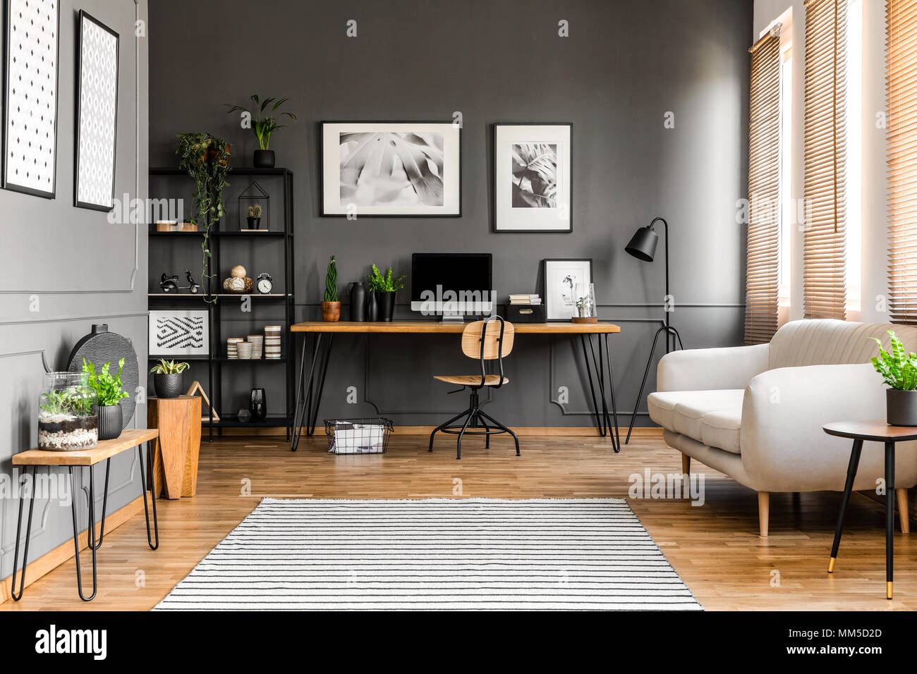 Beige Couch in der Nähe von Holz- Schreibtisch mit Computer Monitor im  Gray's Freelancer Inneneinrichtung mit Plakaten und Anlagen Stockfotografie  - Alamy