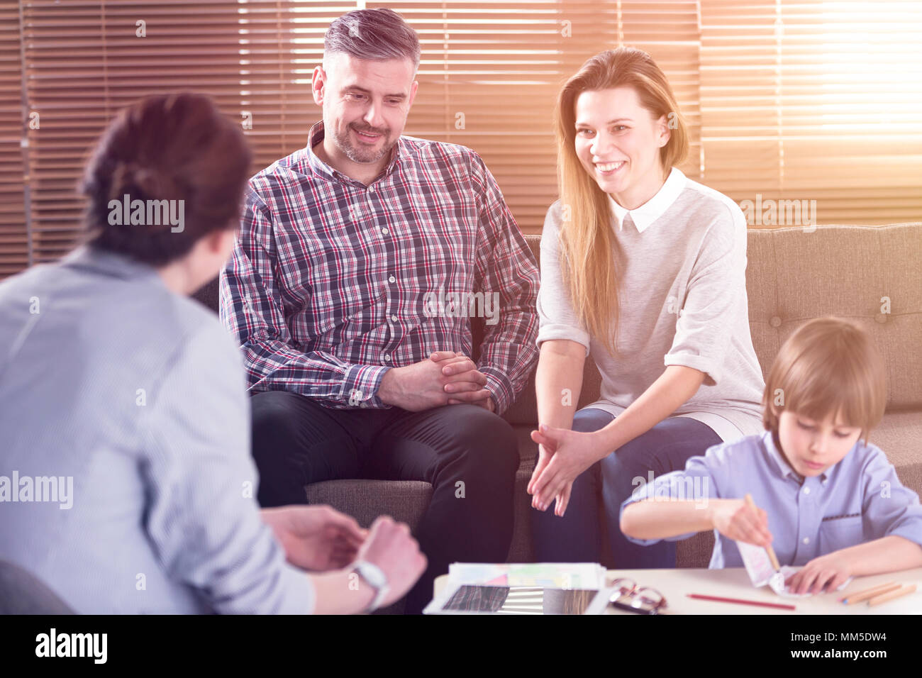 Happy Family im Gespräch mit Lehrer ihres Sohnes im Büro Stockfoto