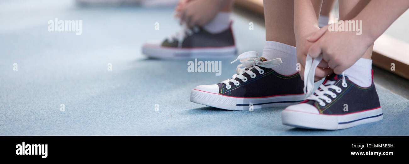 Close-up Kid seine Schuhe binden vor dem Sportunterricht Stockfoto