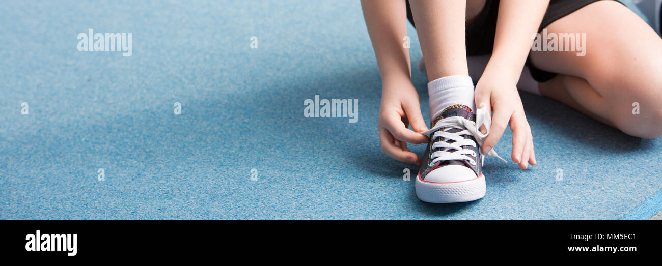 Panorama von Kind seine Schuhe binden vor sportlichen Aktivitäten Stockfoto