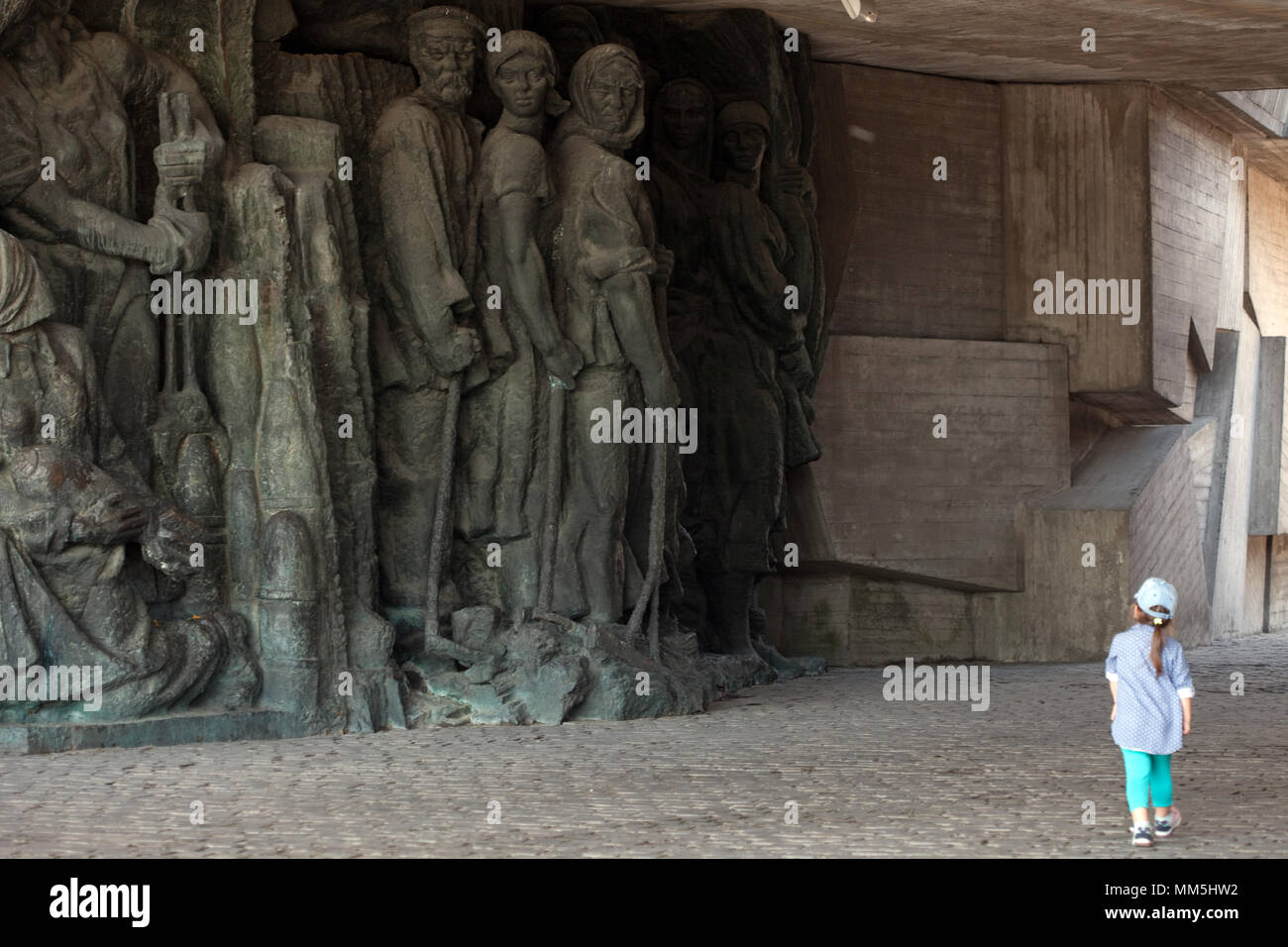 Kind geht durch die Helden des vorderen plastischen Reliefs im Großen Vaterländischen (WWII) Museum, Kiew Stockfoto