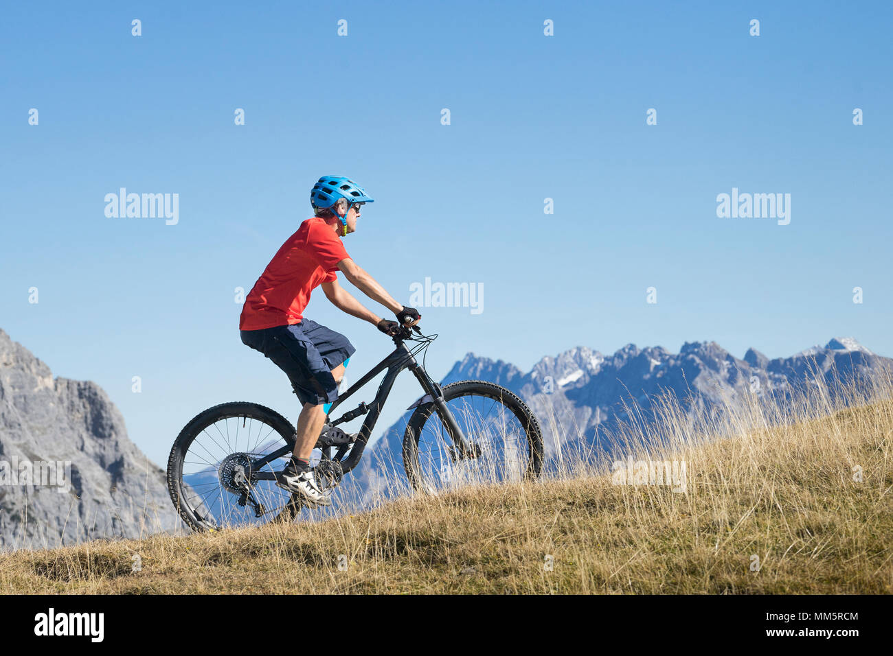 Biker reiten bergauf in alpiner Landschaft, Tirol, Österreich Stockfoto