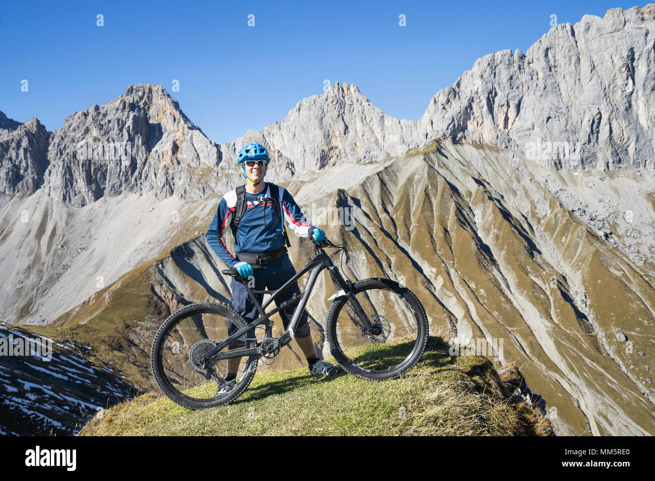 Biker mit Panoramablick auf die Berge, Tirol, Österreich Stockfoto