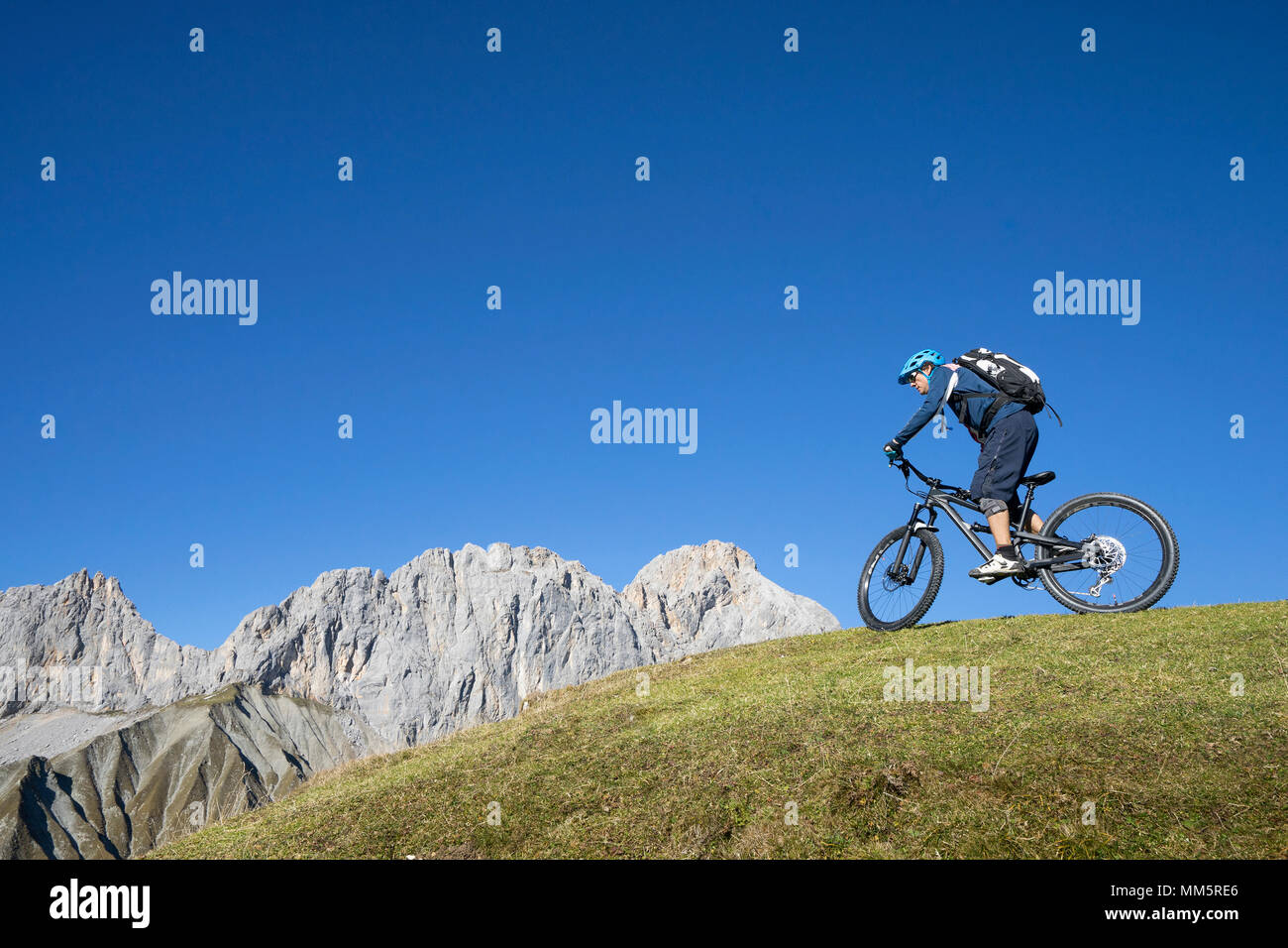 Biker reiten bergauf in alpiner Landschaft, Tirol, Österreich Stockfoto