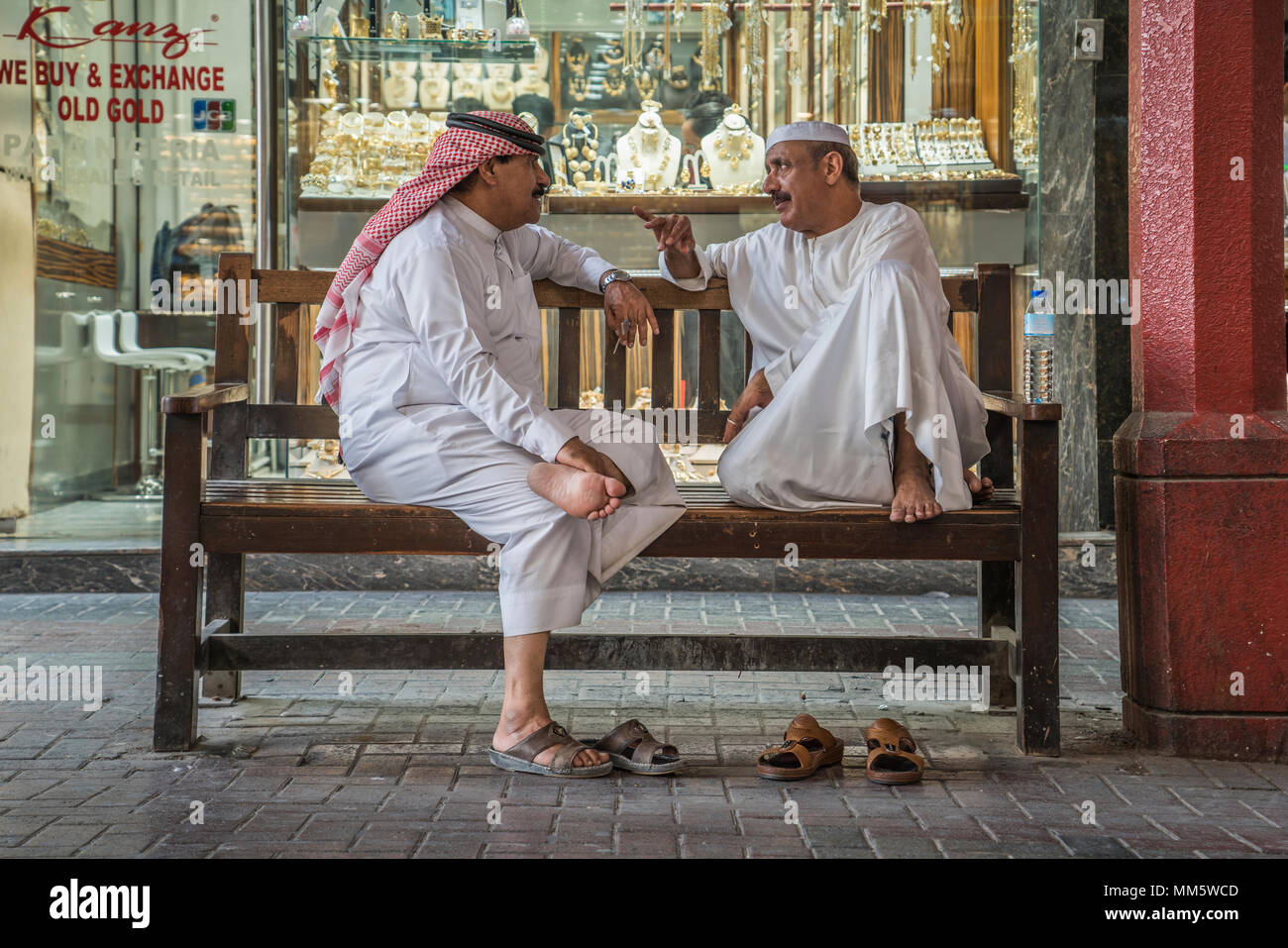 Eine Gruppe von Männern in den Arabischen traditionelles Kleid unterhalten im goldmarkt der Altstadt Souk von Dubai, Vereinigte Arabische Emirate, Naher Osten. Stockfoto