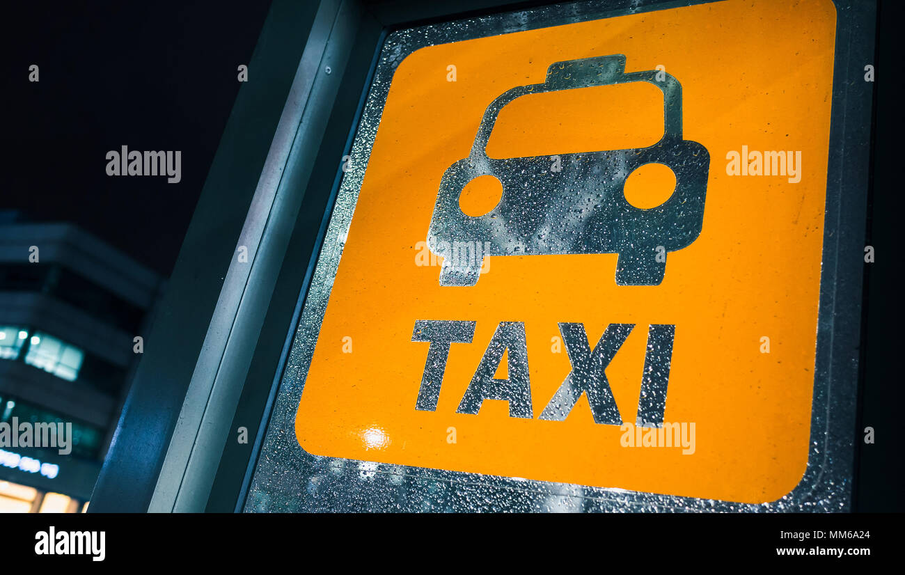 Taxistand. Gelbe Zeichen auf nassen Glas bei regnerischen Nacht Stockfoto