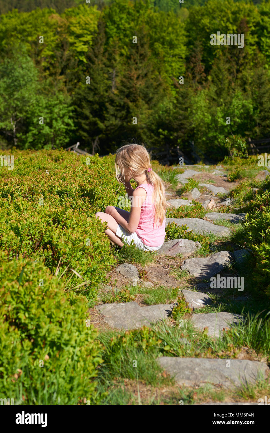 Kind blondes Mädchen pflücken frische Beeren auf blueberry Feld im Wald. Kind pick Blue Berry im Wald. Stockfoto