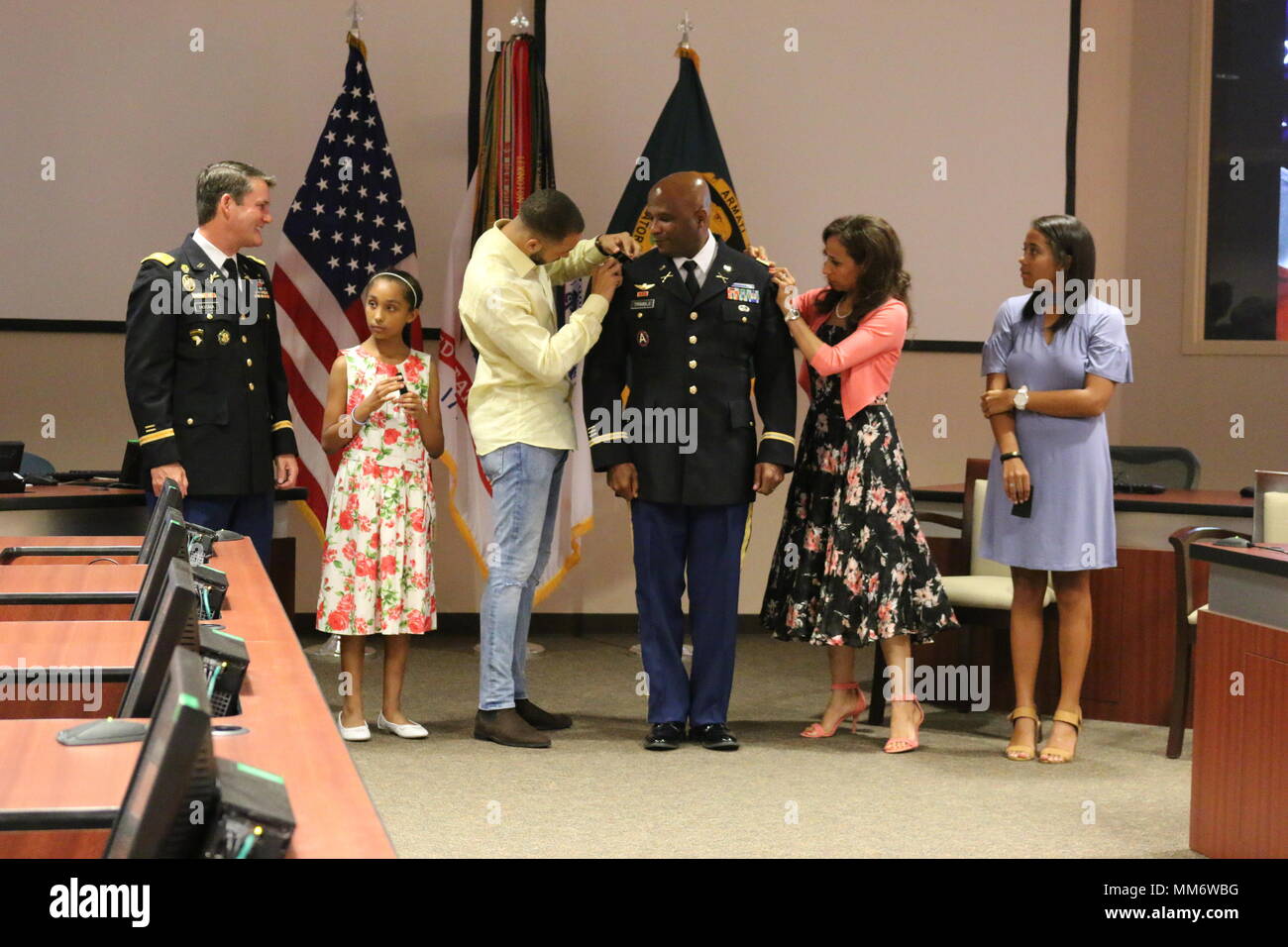 Colonel William Trimble's Sohn, William III, Frau, Amira, die Oberst schulter Markierungen auf Armee die Jacke des Honoree während einer Sept. 8, Förderung Preisverleihung 2017 an der Redstone Arsenal, Ala mit Ihnen sind, von links, amtieren Oberst David Hosna und Töchter Laila und Darby. Trimble ist die militärische stellvertretender Kommandeur der Armee Vertragsparteien Command-Redstone. Stockfoto