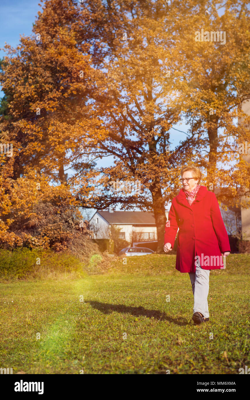 Alte Frau zu Fuß auf der Wiese im Park Stockfoto