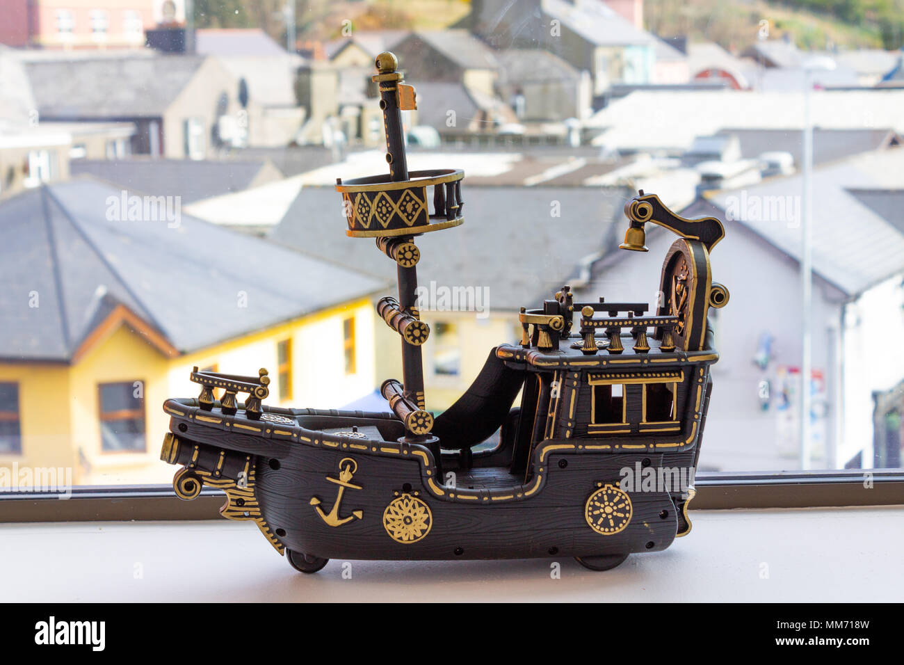 Spielzeug Modell eines einzigen mast Boot in Braun und Gold Farben bemalt, auf der Fensterbank als Fensterdekoration. Stockfoto