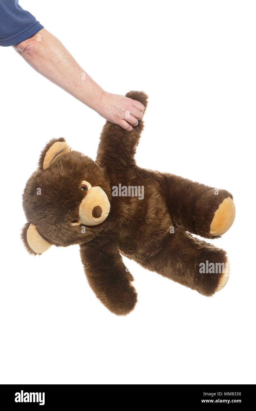 Detail von der Hand eines männlichen Holding ein brauner Teddybär vor einem weißen Hintergrund isoliert. Stockfoto