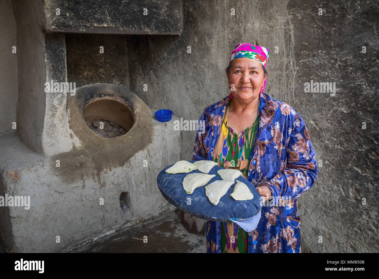 Buchara, Usbekistan - 20. April 2018: Eine ältere Frau ist die Vorbereitung der samsa in der tandoor - einem traditionellen usbekischen Ofen Stockfoto