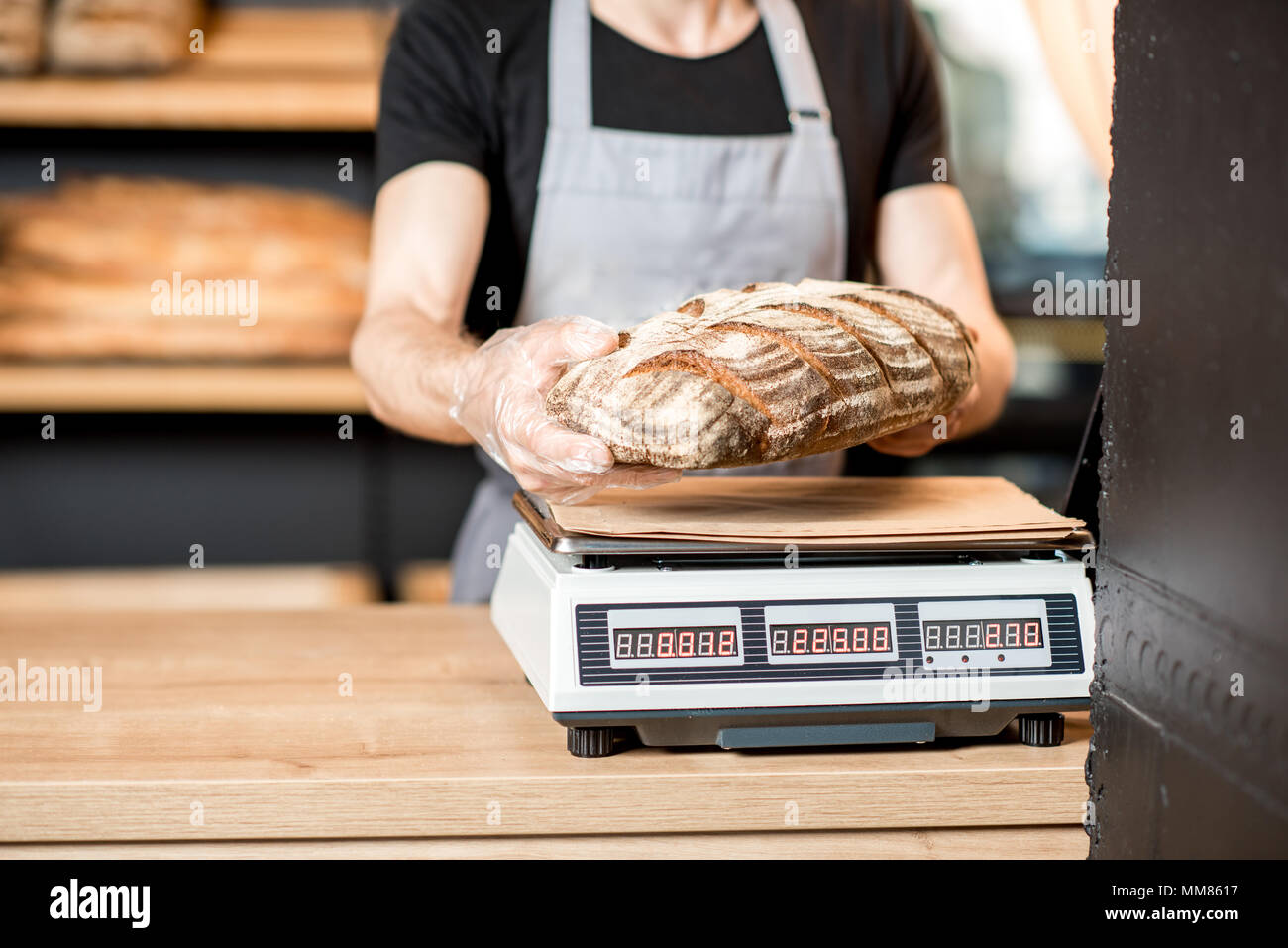 Verkäufer Gewichtung ein Brotlaib Stockfoto