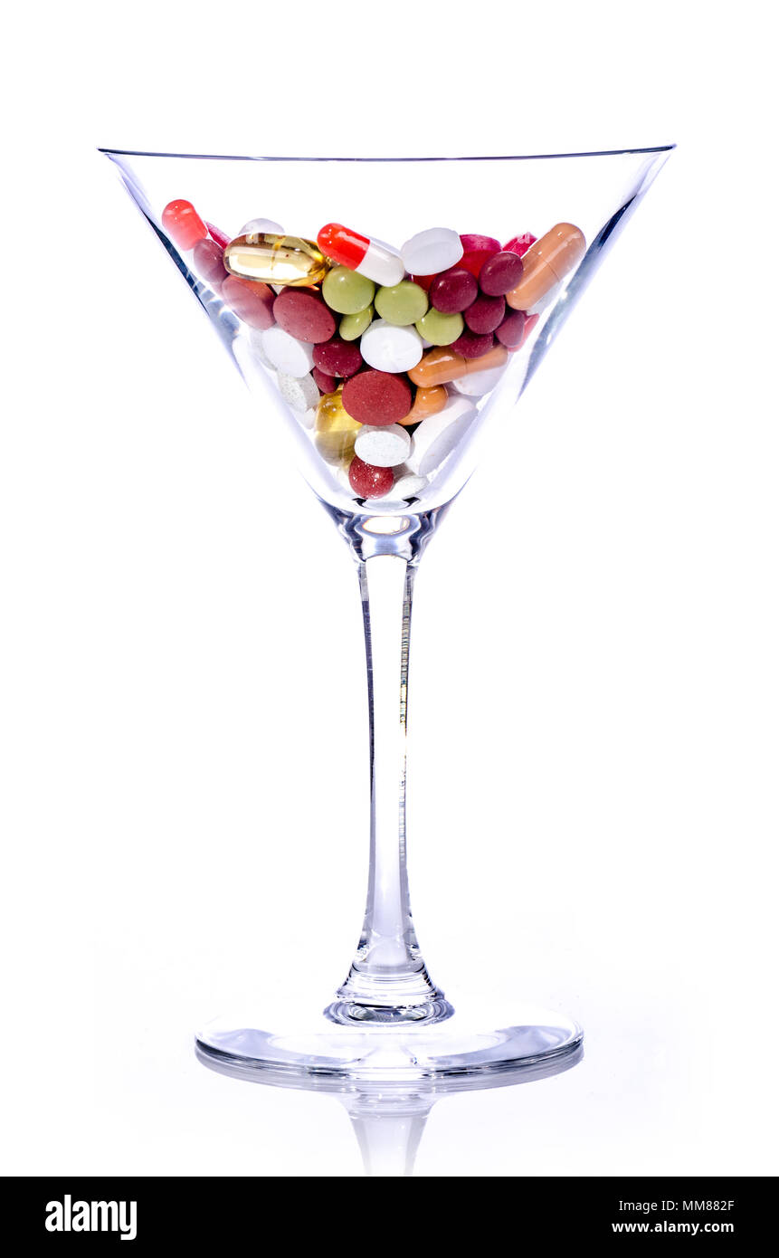 Pillen in einem Cocktail Glas, weißer Hintergrund, isoliert Stockfoto