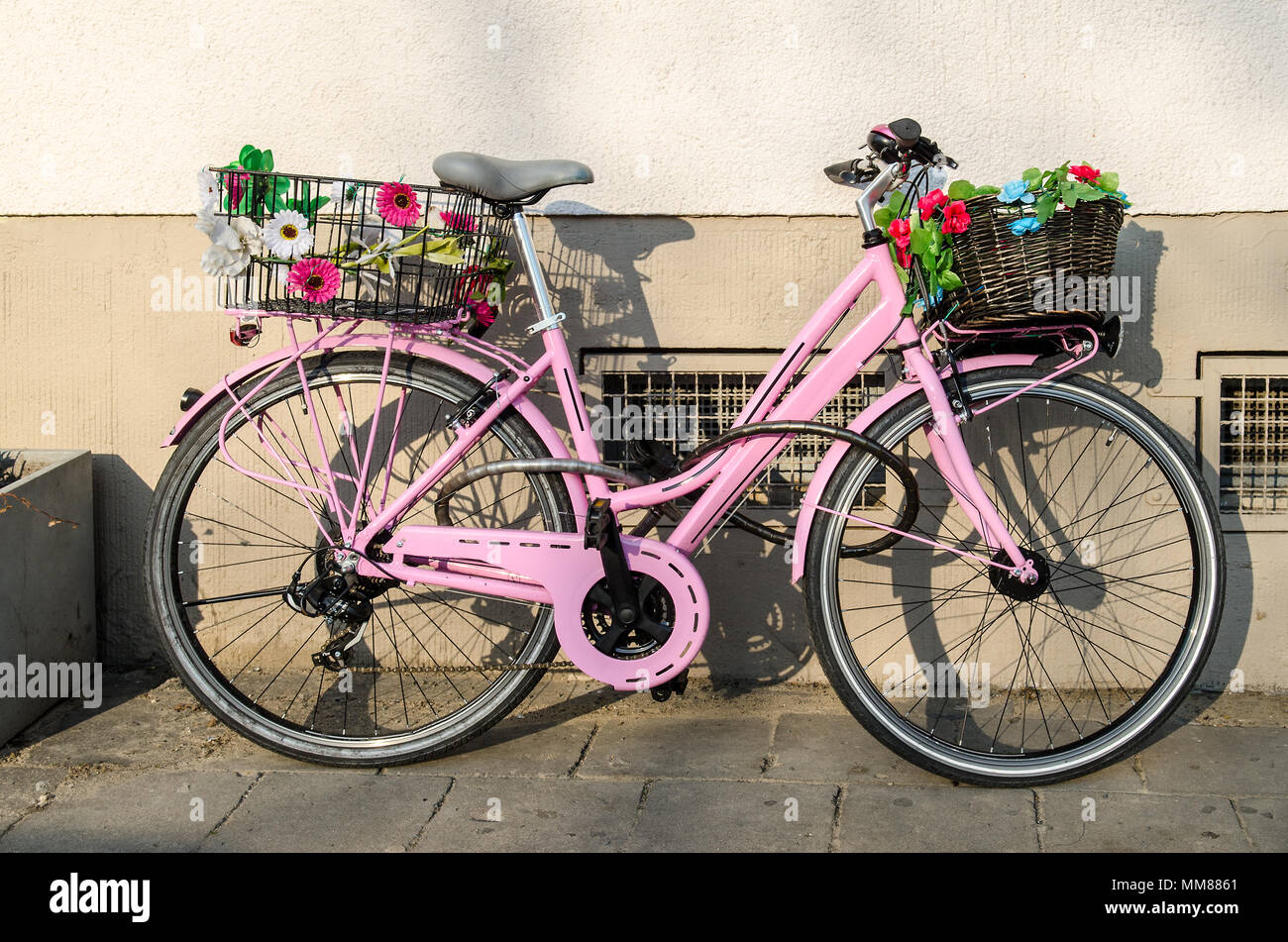 Alte rosa Fahrrad mit Blumen vor einem Gebäude Stockfotografie - Alamy