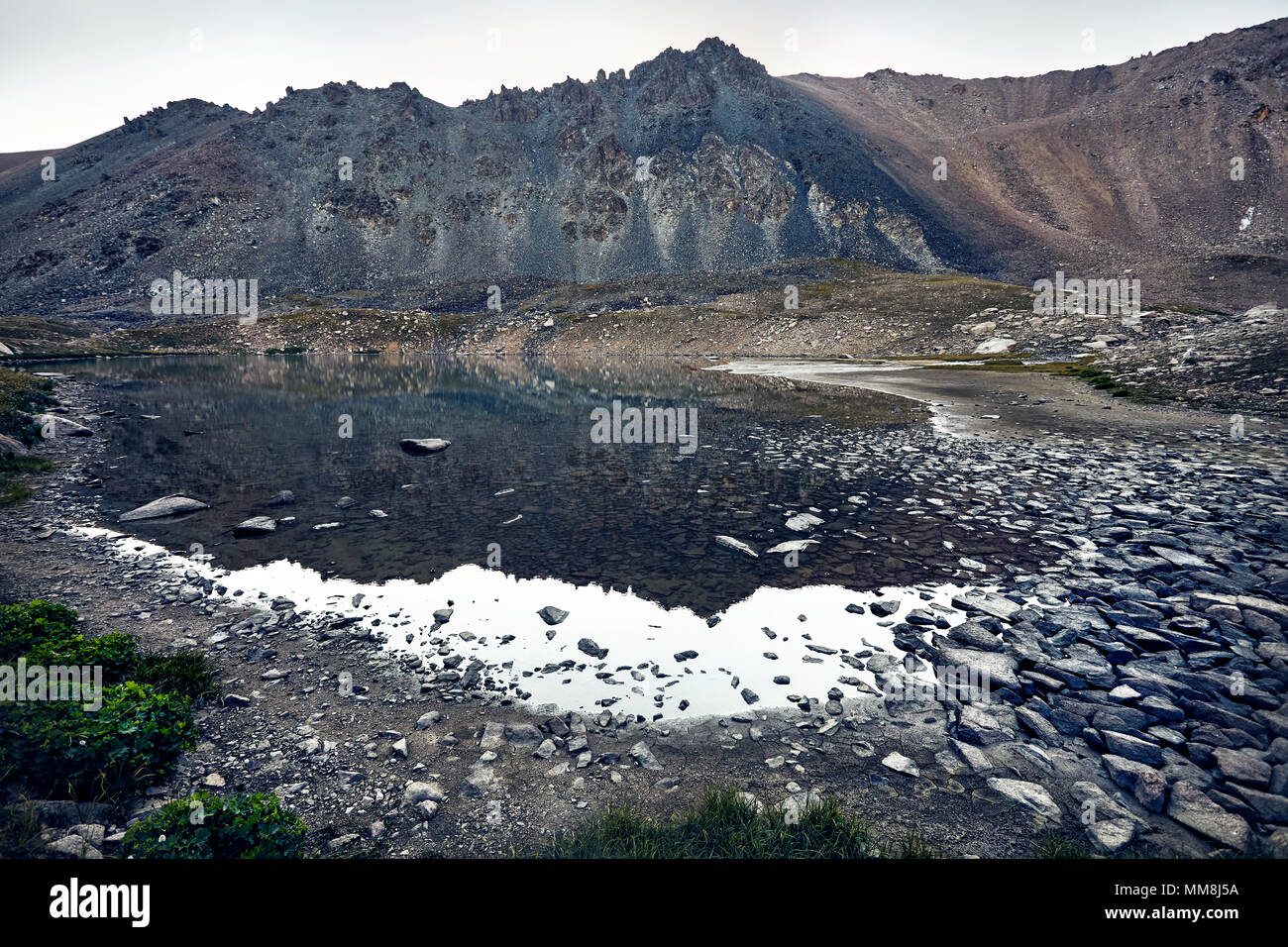 Landschaft der Rocky Mountains und den See am grauen bewölkten Himmel Hintergrund Stockfoto