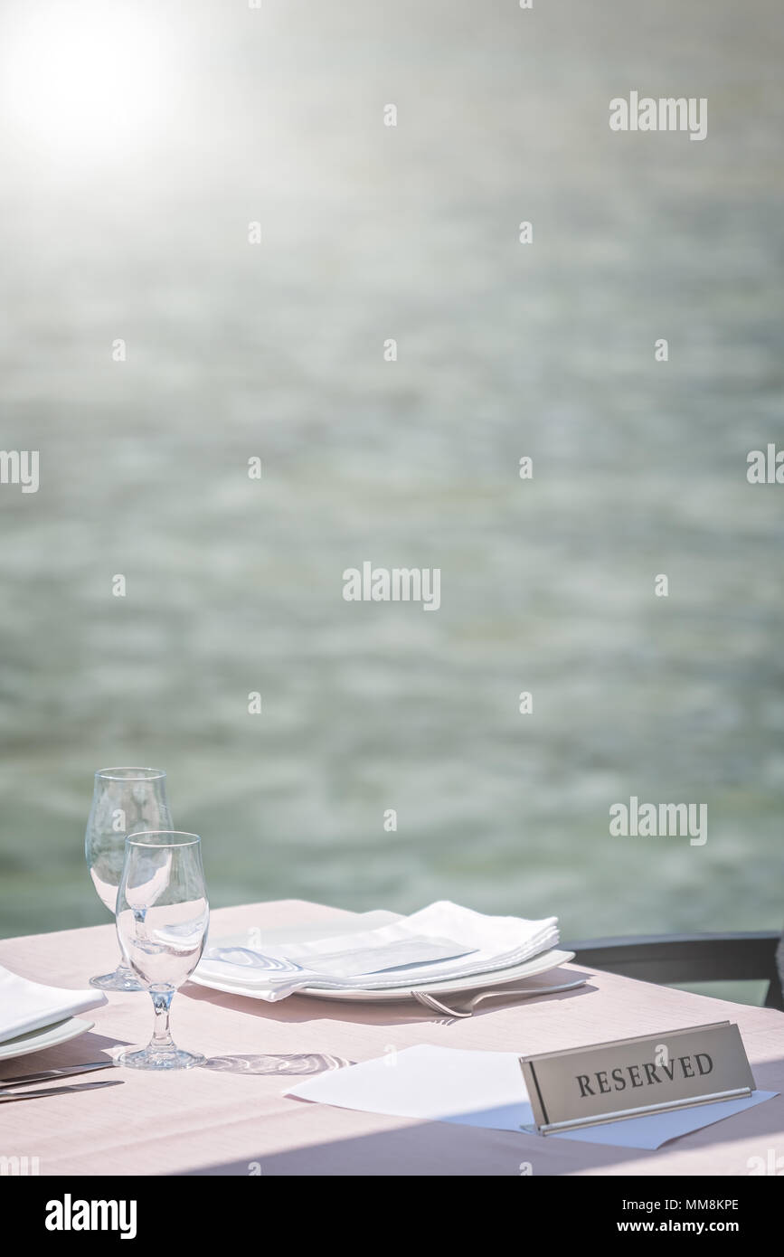 Leere Gläser auf einen reservierten Restaurant im freien Tisch in einem Badeort Stockfoto