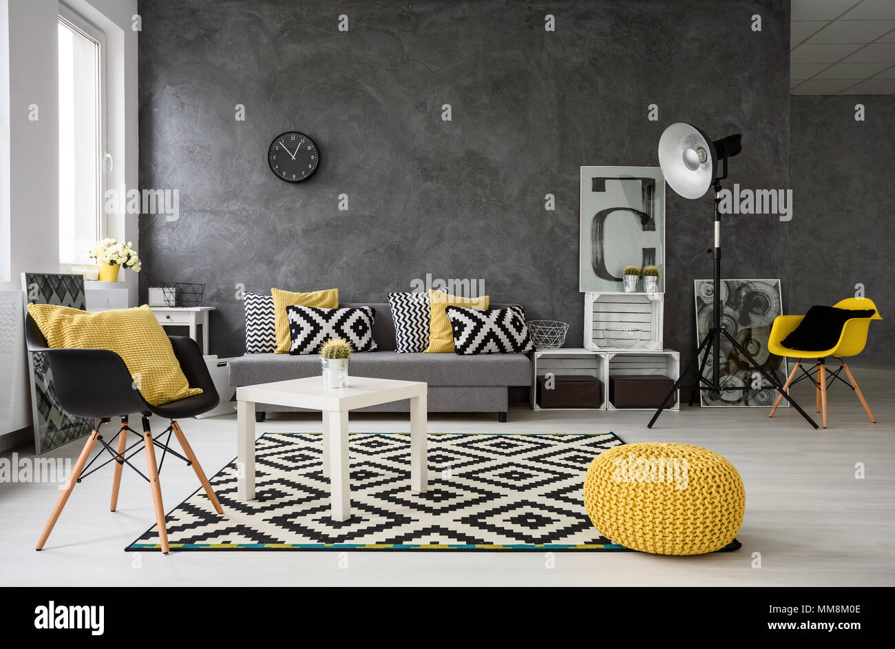 Geräumige, grau Wohnzimmer mit Sofa, Stühle, Stehlampe, kleiner Tisch,  Dekorationen in Gelb, Schwarz und Weiß Stockfotografie - Alamy