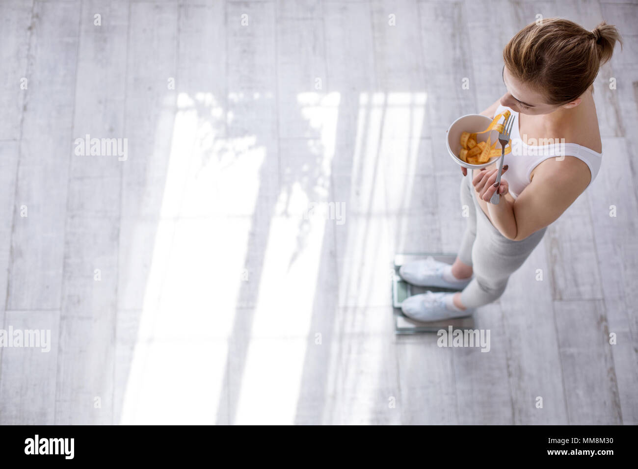 Schöne junge Frau mit einer Schüssel mit Zentimeter Band Stockfoto