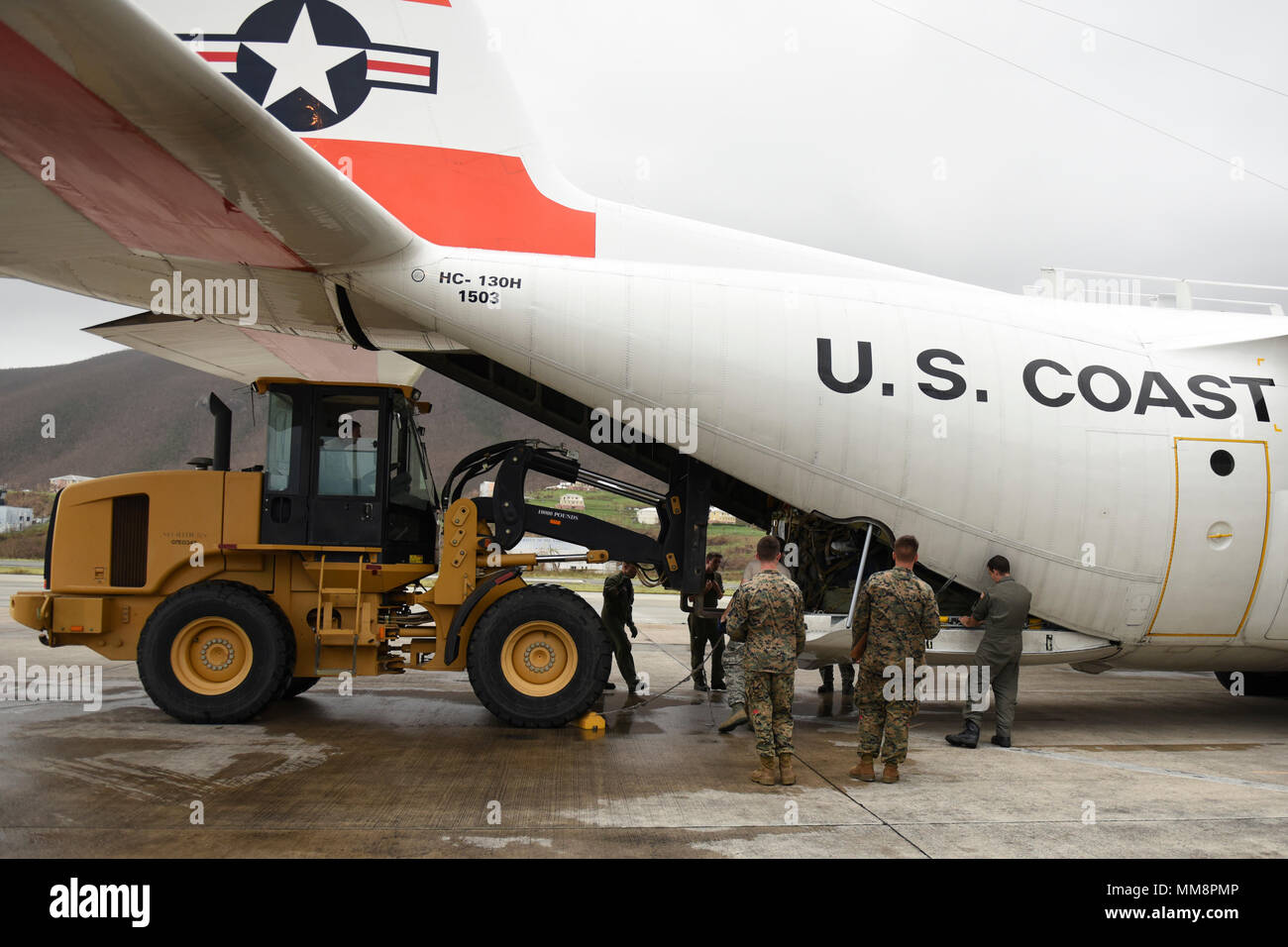 Lockheed Martin C-130 Hercules ist ein viermotoriges Turboprop-Transportflugzeug der United States Coast Guard. Das Archivbild dokumentiert die Entnahme von Notvorräten aus dem Flugzeug am Cyril E. King Airport in St. Thomas, US-Jungferninseln, am 14. September 2017, zur Unterstützung von Hurrikan Irma Hilfseinsätzen. Stockfoto