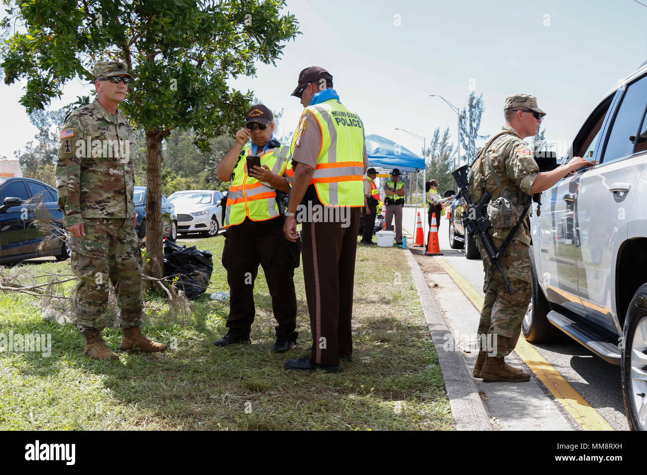 Das 1st Battalion, 128th Infantry Regiment, ist eine Einheit der Nationalgarde der Wisconsin Army, die dem 32nd Infantry Brigade Combat Team zugeordnet ist und im September 2017 nach Florida für Hurrikan Irma eingesetzt wurde. Das Archivbild dokumentiert die Koordination zwischen Personal der Nationalgarde und Strafverfolgungsbehörden in Miami-Dade während der öffentlichen Sicherheitseinsätze. Stockfoto