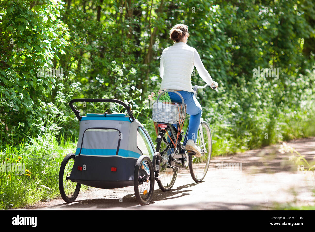Junge Mutter mit Baby Reiten Fahrrad Fahrradanhnger im sonnigen Sommer  Park. Fit aktive Frau Radfahren mit Kind. Sicherer Transport von kleinen  Kindern. Mom Stockfotografie - Alamy