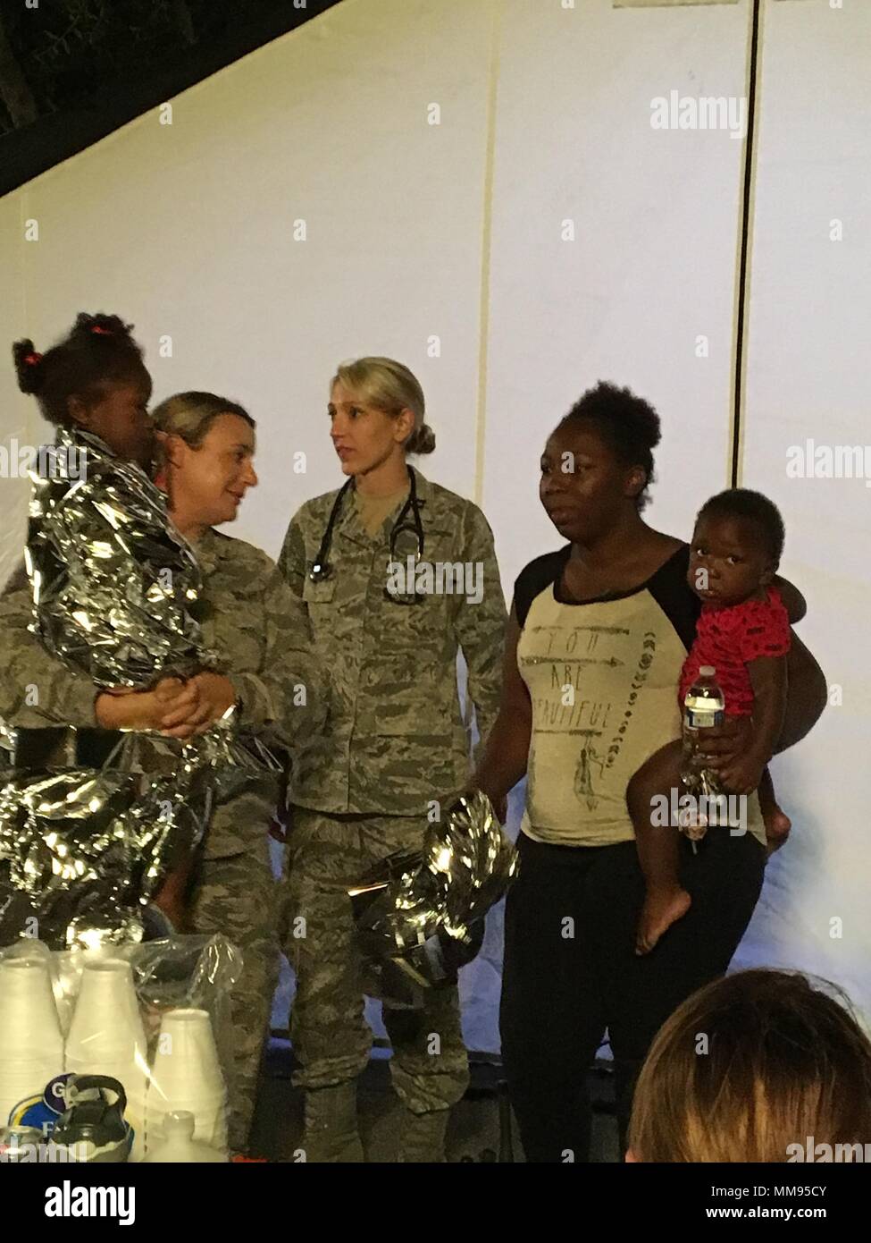 Mitglieder von der Nebraska Air National Guard 155 medizinische Gruppe bereitstellen zu Hurrikan Harvey Erleichterung in Texas September 2 bis 9, 2017 Lincoln, Nebraska. 44 Medical Group Personal zu Texas bereitgestellten Hilfe und Unterstützung medizinischer triage Fähigkeiten als Cbrne (Chemische, biologische, radiologische, nukleare, und ertragreiche Explosivstoffe) CERFP (Enhanced Response Force Paket). Nebraska National Guard Medic Master Sgt Kristin Bovinet und Arzt Kapitän Avery Seiten geben den endgültigen Ableitung Anweisungen, die Mutter des Patienten und helfen, die Mutter ihrer Kinder zu ihrem Fahrzeug erhalten Sie in der Stockfoto